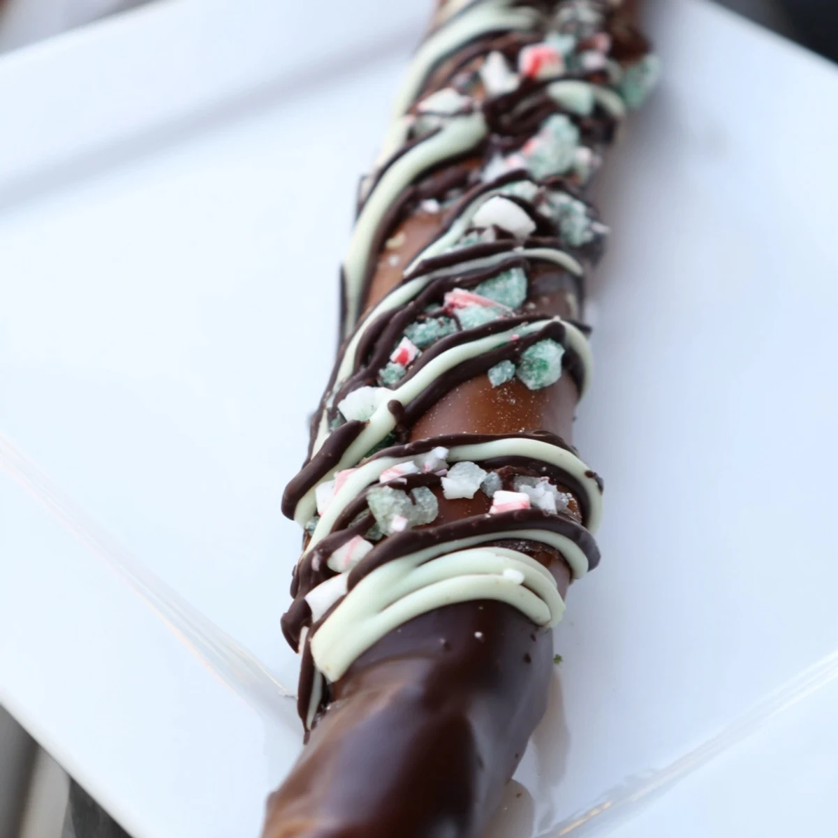 Dark chocolate peppermint bark pretzel rods are dipped in rich dark chocolate and coated with crushed candy canes for a sweet, salty, and minty holiday snack.