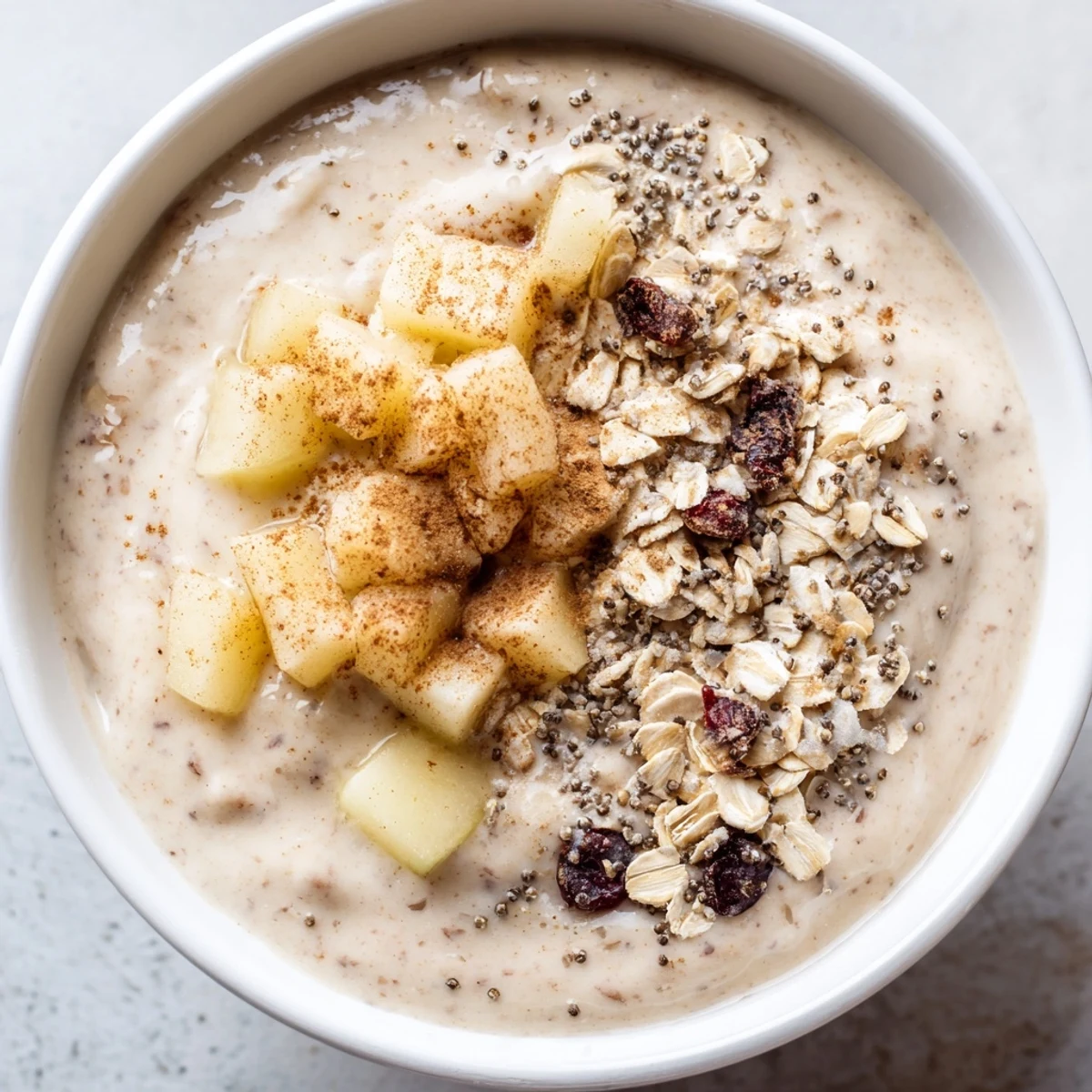 Two frosted glasses of Winter Smoothie Blend with a sprinkle of nutmeg, served beside fresh pear slices.