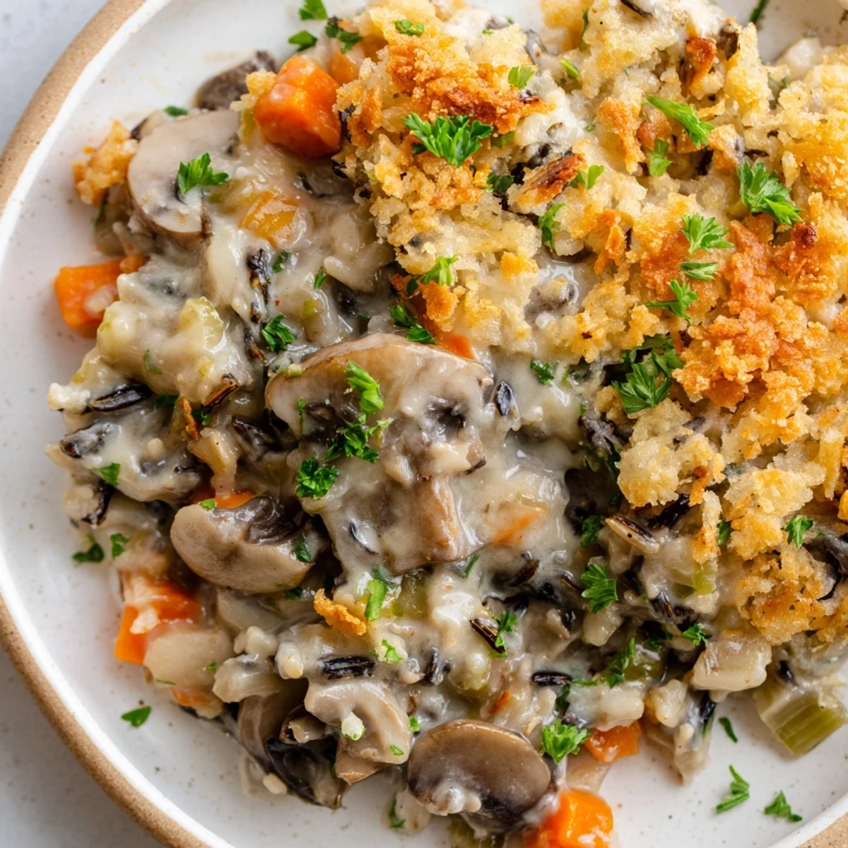 Creamy Mushroom and Wild Rice Casserole baked golden, bubbling with savory mushrooms and rich sauce in a white dish.