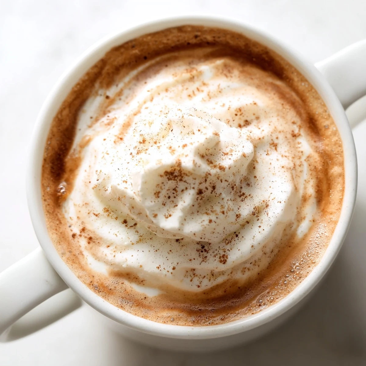 Cozy Gingerbread Spiced Latte with Almond Milk poured into a rustic mug, showcasing creamy texture and aromatic holiday spices.
