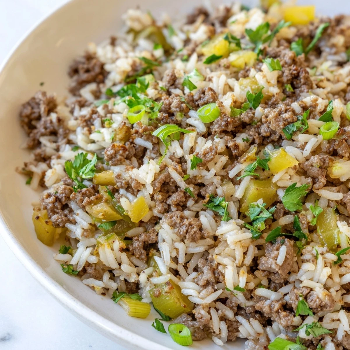 Cajun Dirty Rice with ground beef simmering in a skillet, featuring aromatic vegetables and bold Cajun spices for a hearty meal.