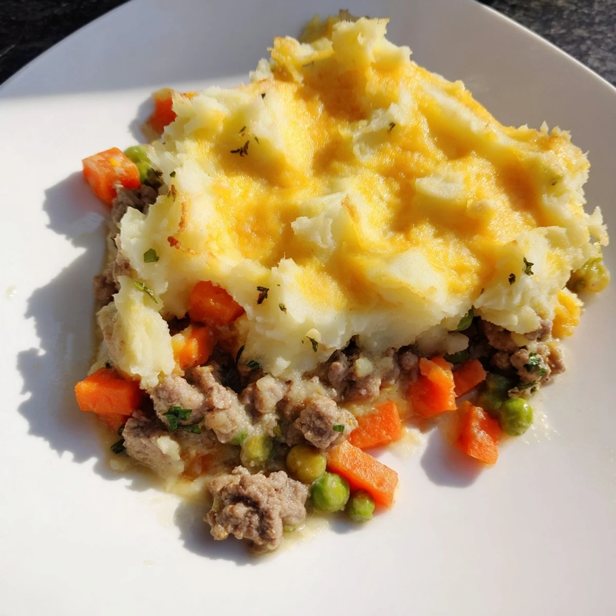 A close-up of baked Shepherd's Pie with savory lamb and tender vegetables, bubbling with cheesy potato topping.