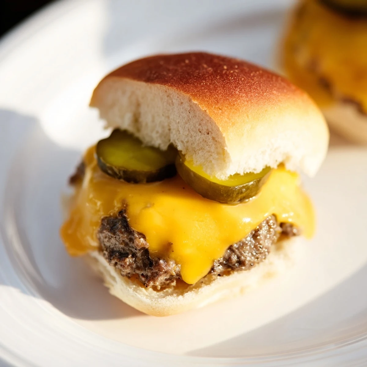 Mouthwatering beef sliders with cheese and pickles nestled on soft buns, perfect for a casual game-day spread.