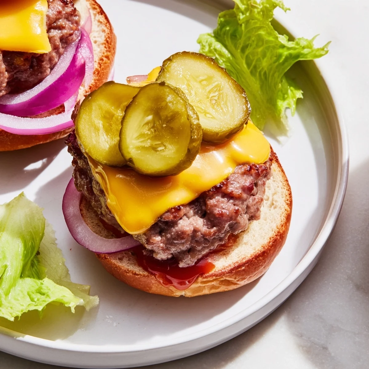 Juicy beef patties topped with melted cheese and pickles, ready for a party platter.