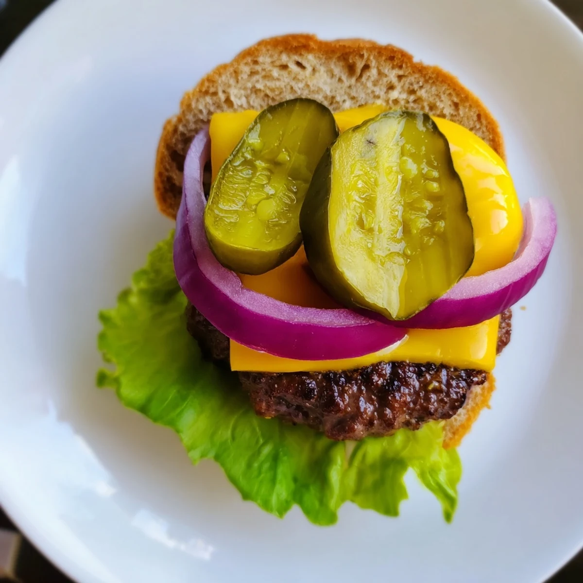 Golden-brown beef sliders with melted cheddar cheese and crisp dill pickle slices on toasted buns.
