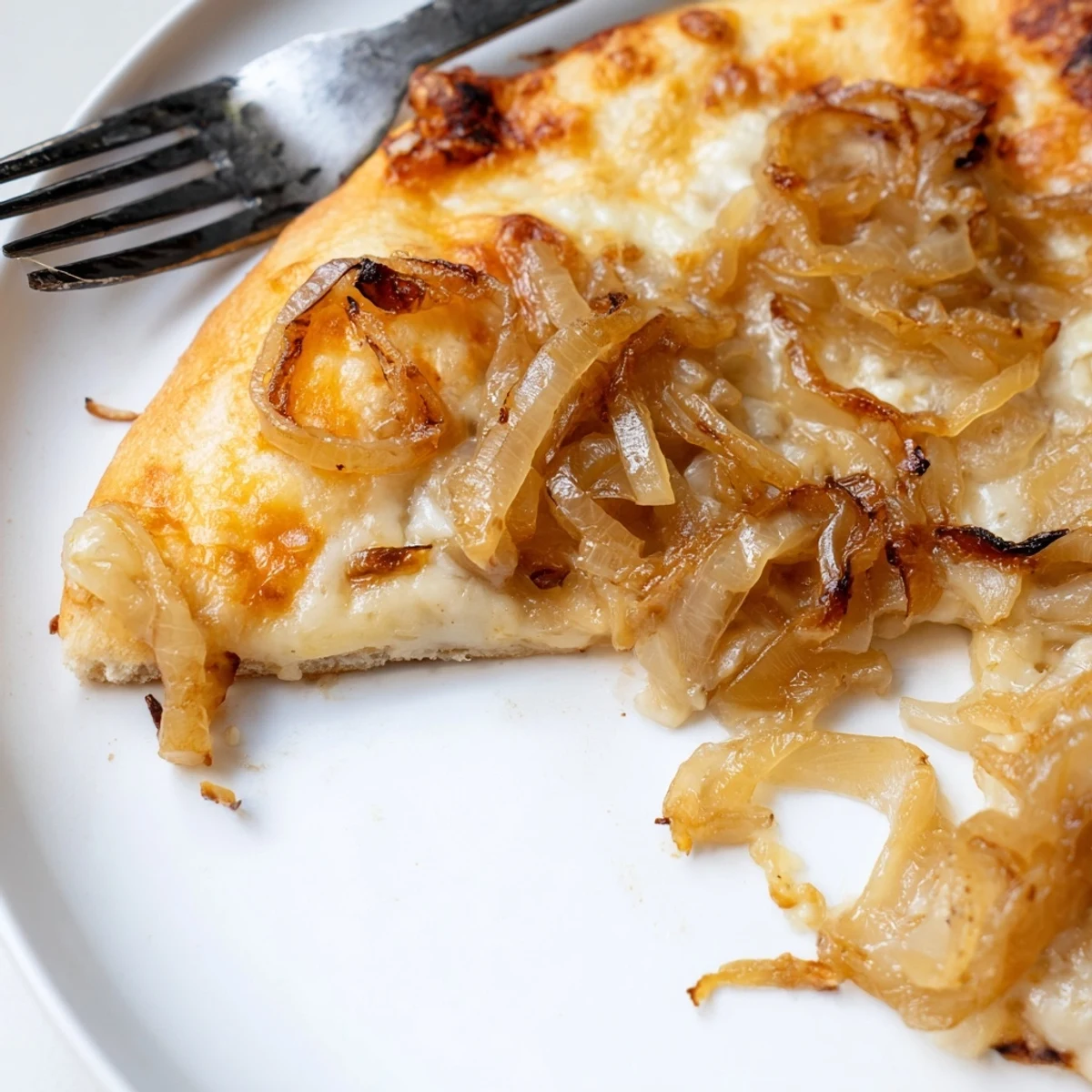 Overhead shot of a fresh Caramelized Onion Pizza with Melty Cheese garnished with fresh thyme on a kitchen surface.