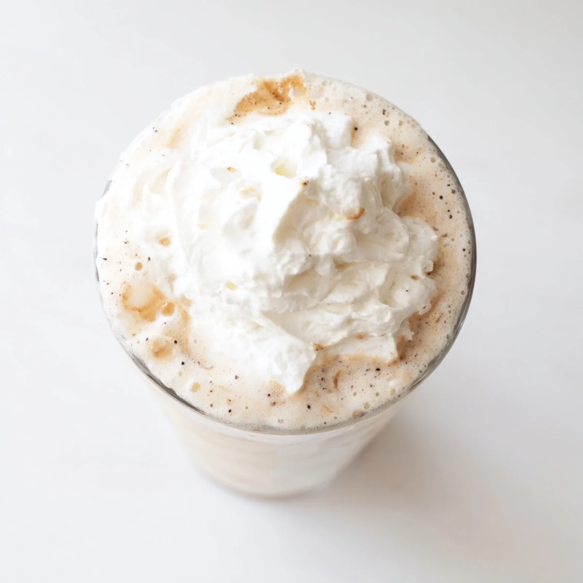 Creamy Vanilla Bean Frappuccino blended with ice and topped with whipped cream in a tall glass.