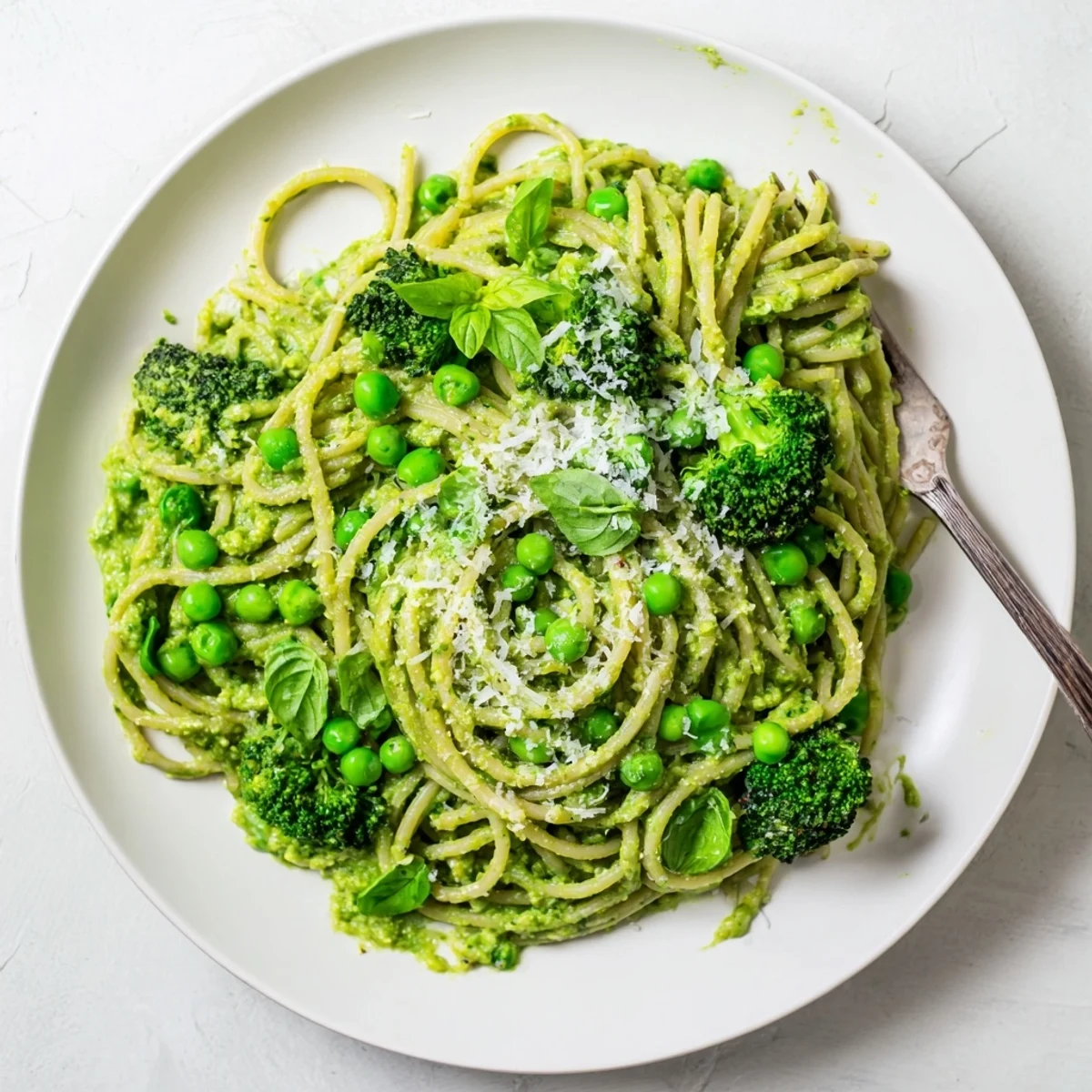 Creamy Veggie Smuggler Avocado Pasta served with fresh basil and lemon zest in a white bowl.