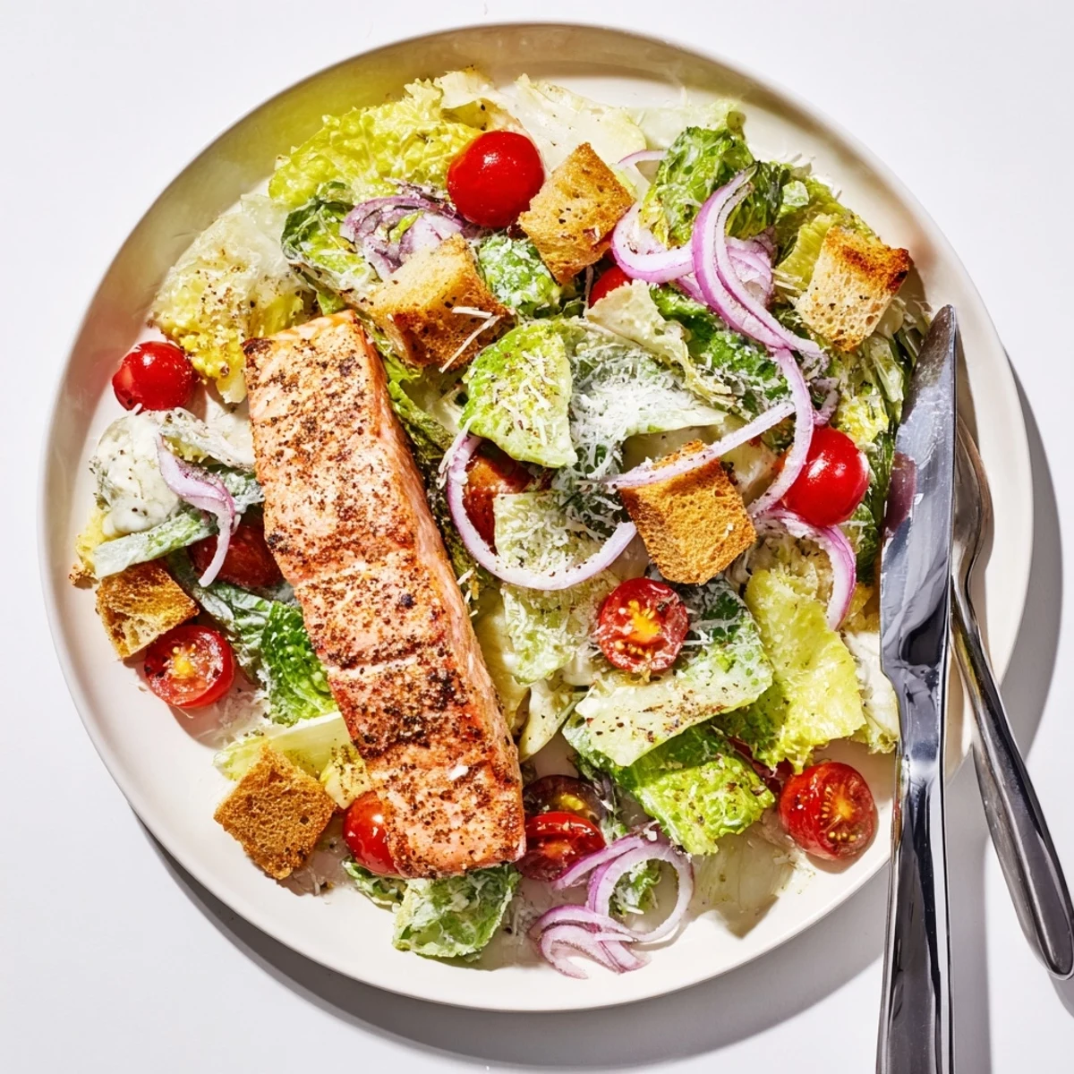 Fresh salmon Caesar salad bowl featuring charred fish, crunchy croutons, and tangy homemade dressing