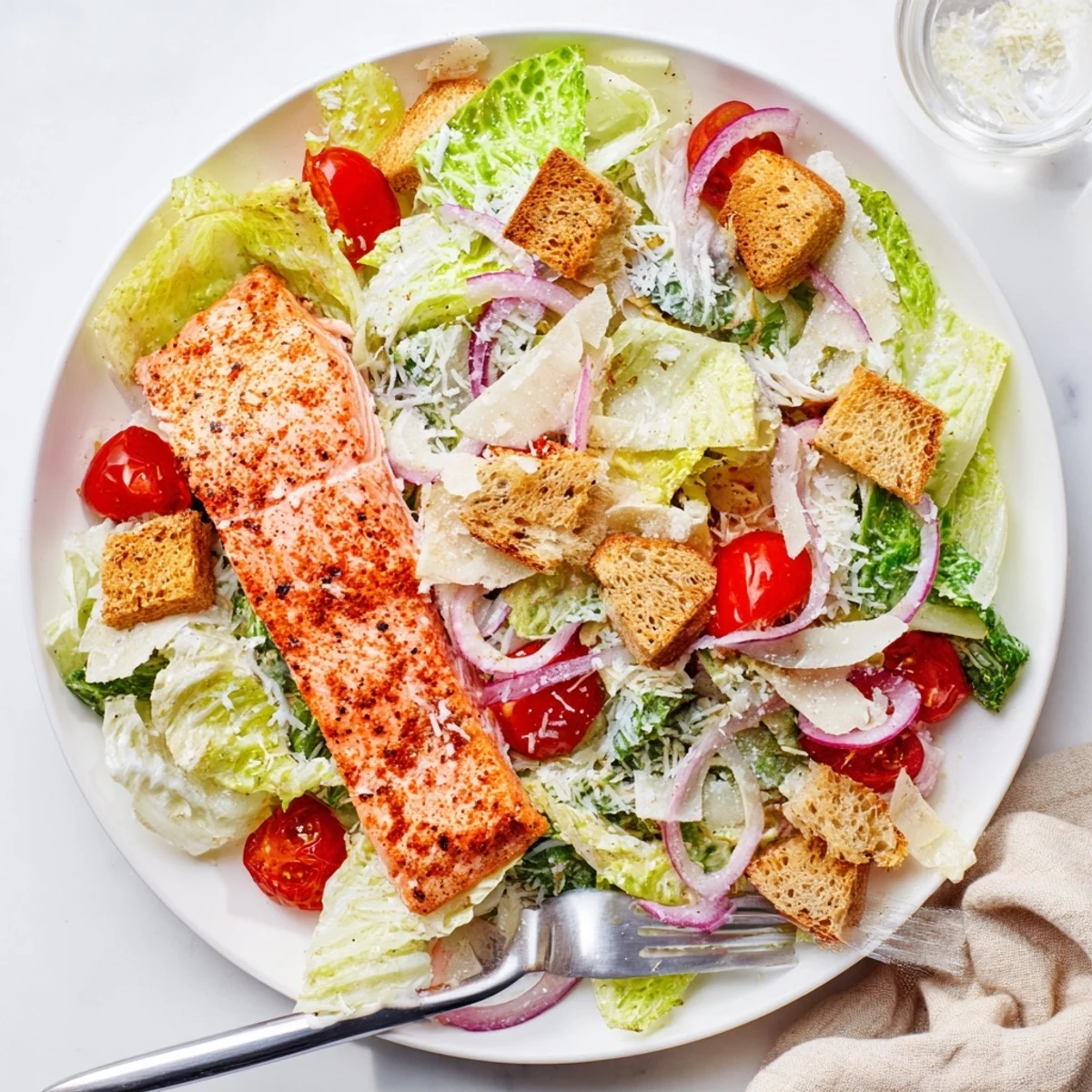Vibrant plate of salmon Caesar salad topped with grilled fillet, Parmesan, and crisp lettuce