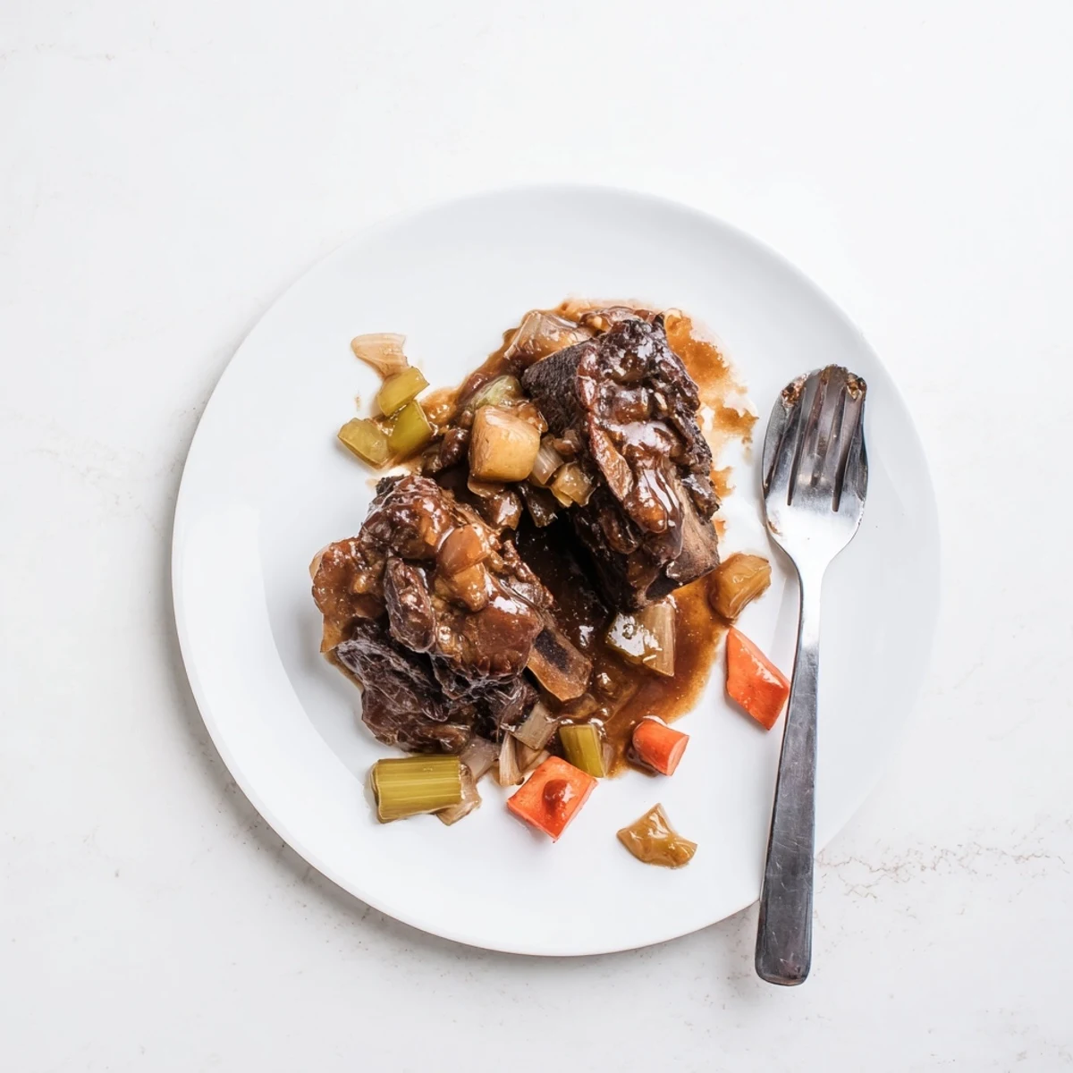 Close-up of fall-off-the-bone maple bourbon glazed short ribs with thick sauce pooling around the bone-in cuts on a rustic wooden board