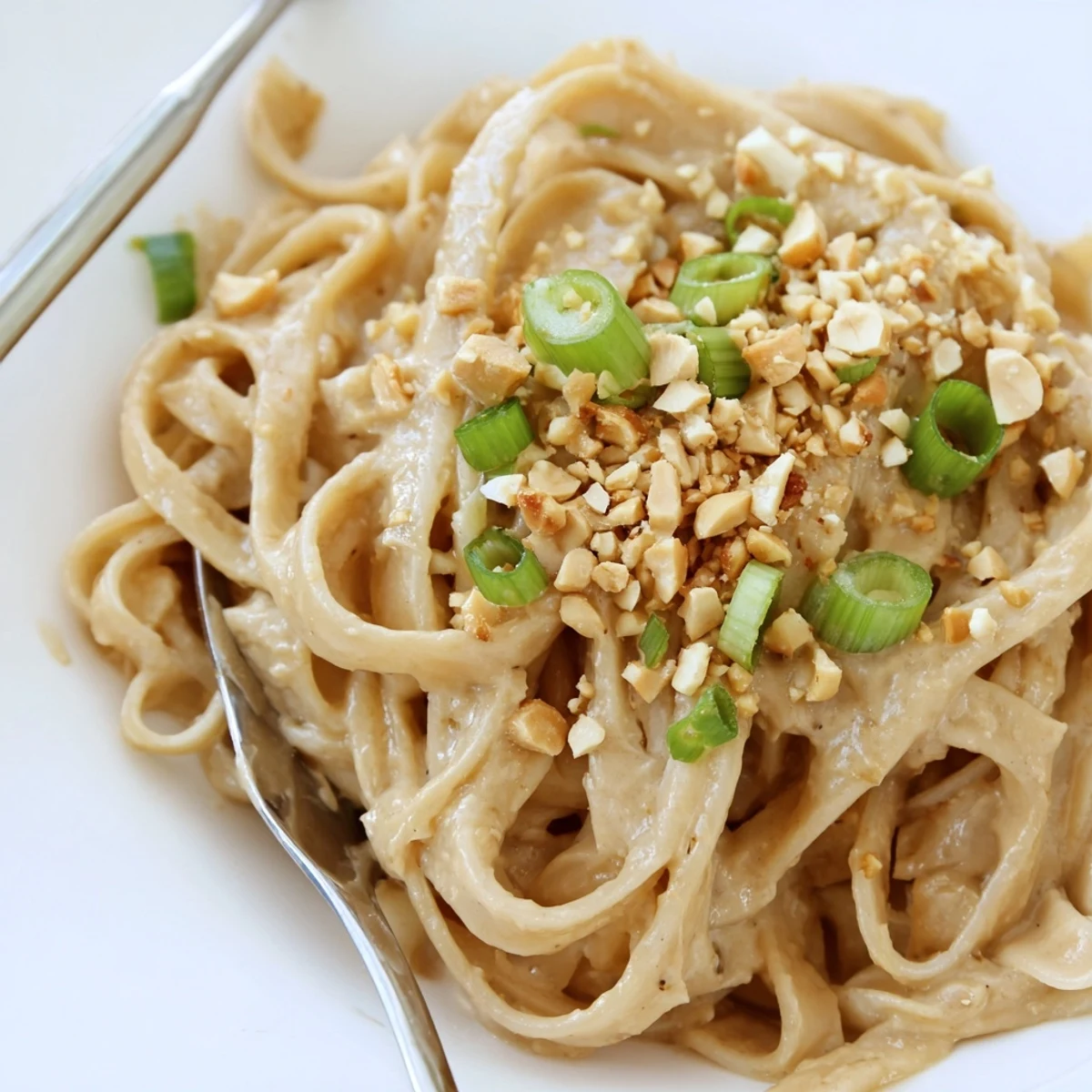 Twirled sticky peanut butter noodles drizzled with rich sesame peanut sauce and topped with fresh cilantro