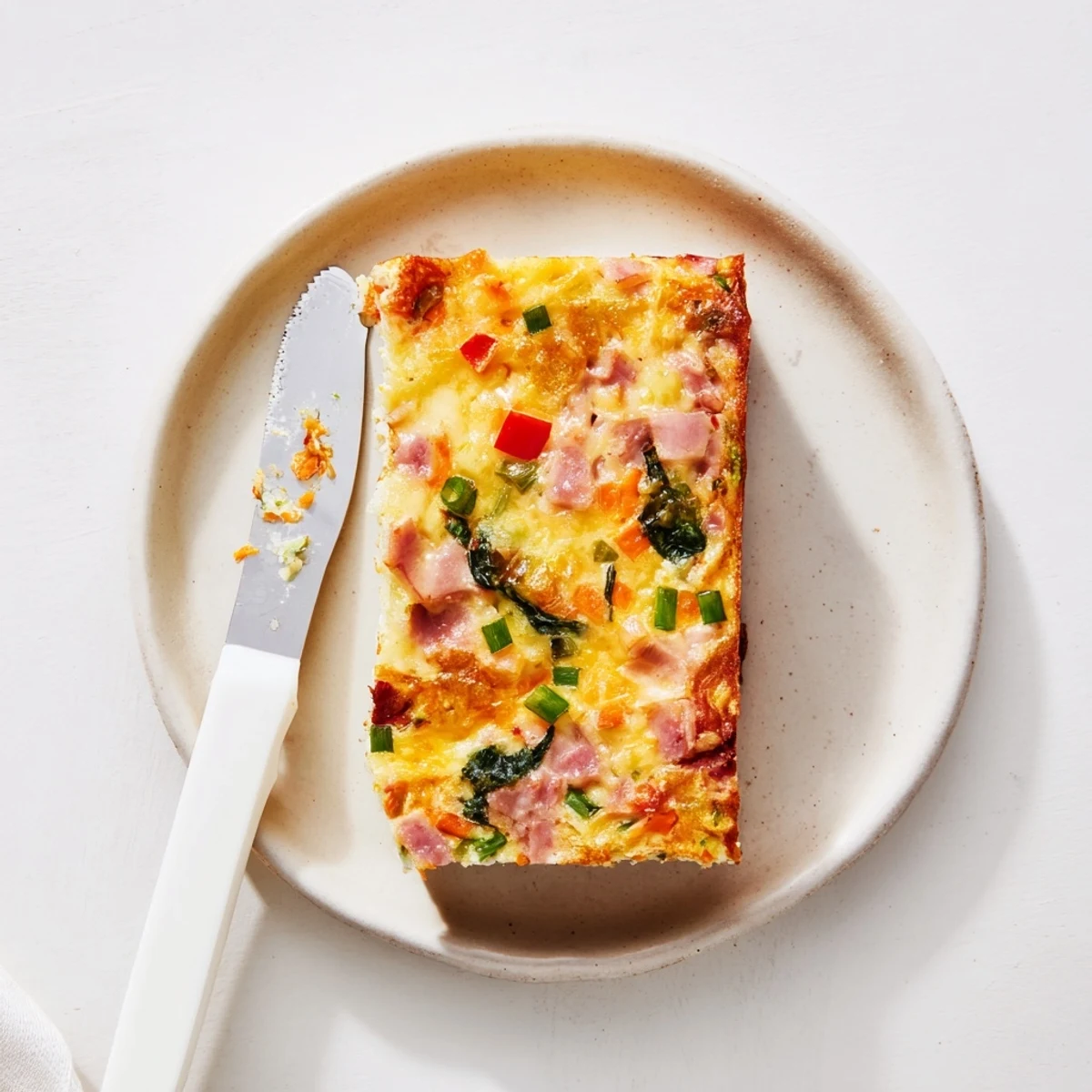 Moist vegetable and ham slice loaf topped with fresh chives, perfect for brunch