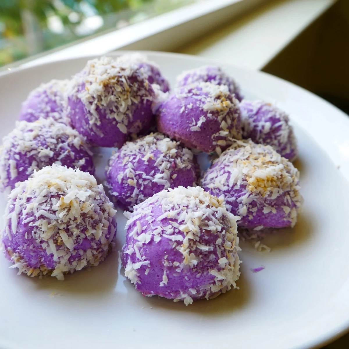 Golden coconut ube besito cookies with vibrant purple dough and snowy coconut coating