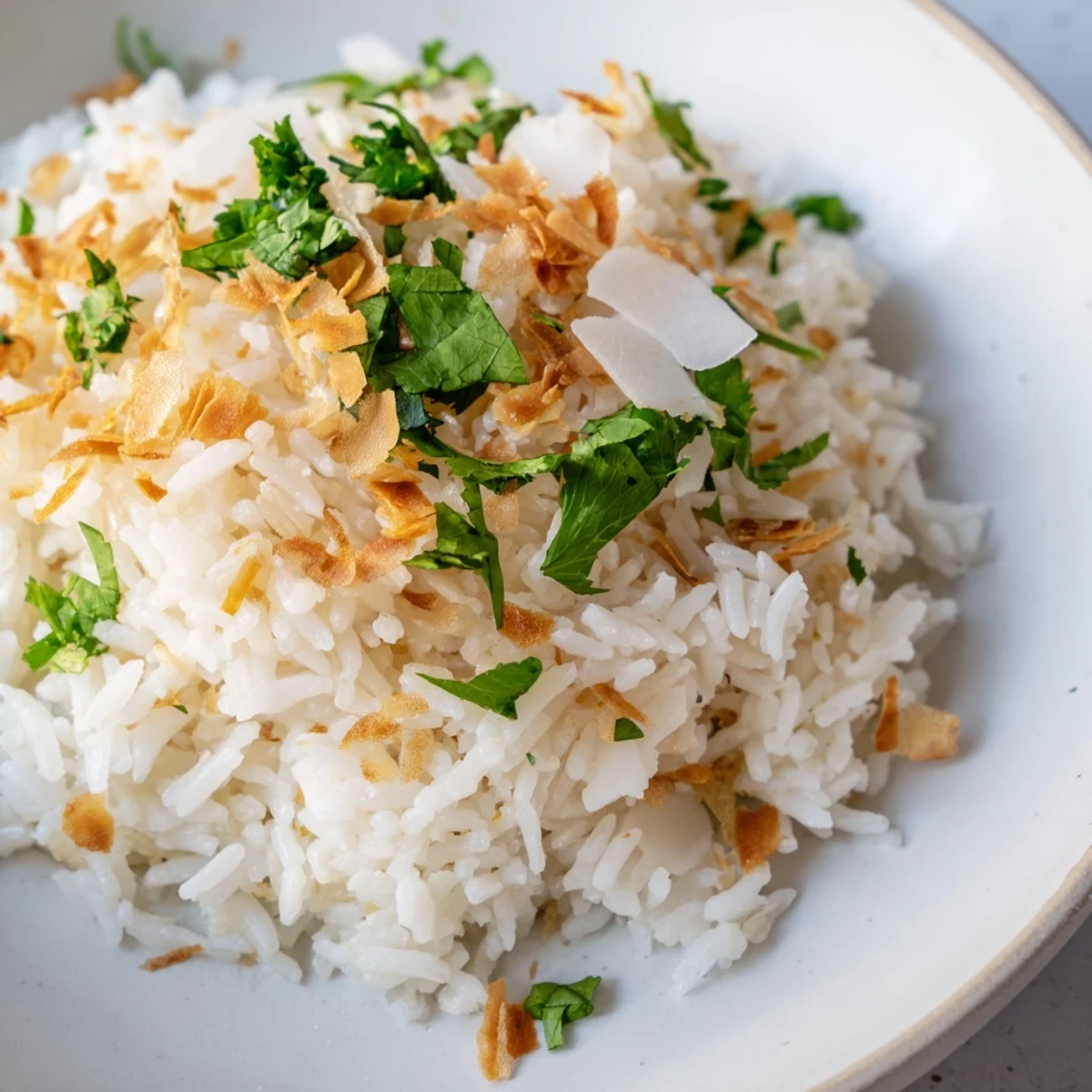 Steaming jasmine coconut rice in a white saucepan, fragrant and ready for curries or grilled meats