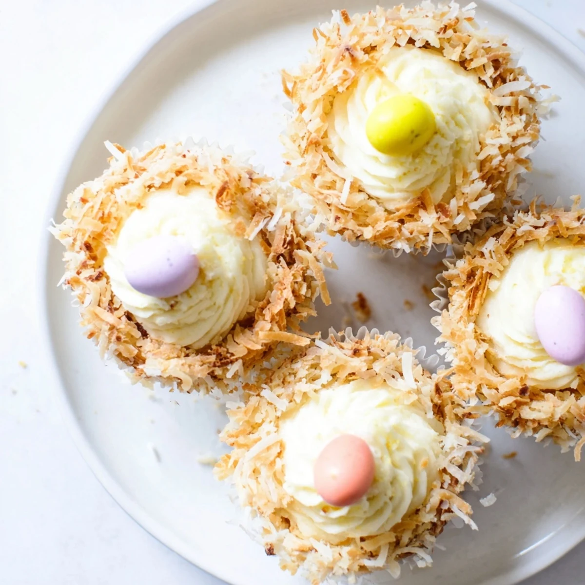 Spring dessert of coconut nest cupcakes with golden toasted coconut nests holding mini chocolate egg treats