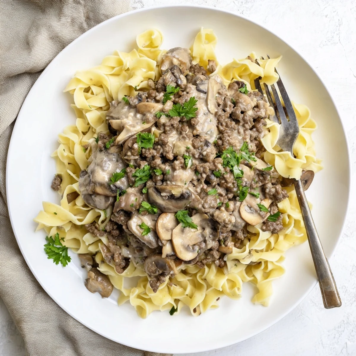 Creamy hamburger stroganoff with tender ground beef and mushrooms served over egg noodles