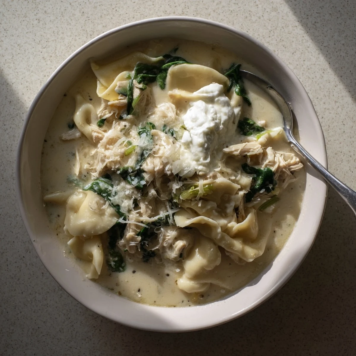 Hearty chicken white lasagna soup garnished with parsley and extra mozzarella cheese over tender pasta pieces