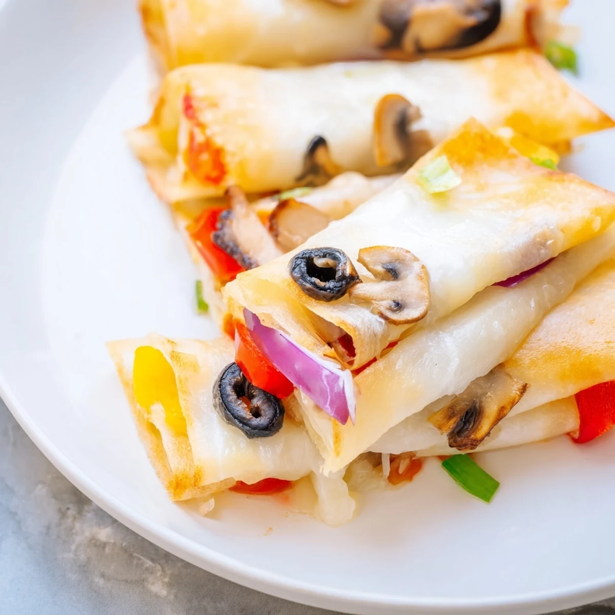 Golden pan-fried rice paper pizza rolls with melted mozzarella and colorful vegetable fillings