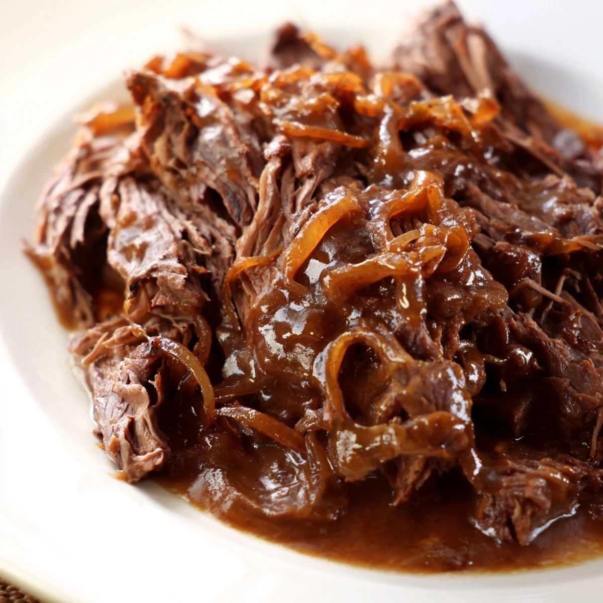 Tender French onion pot roast with caramelized onions and melted Gruyère cheese on a serving platter