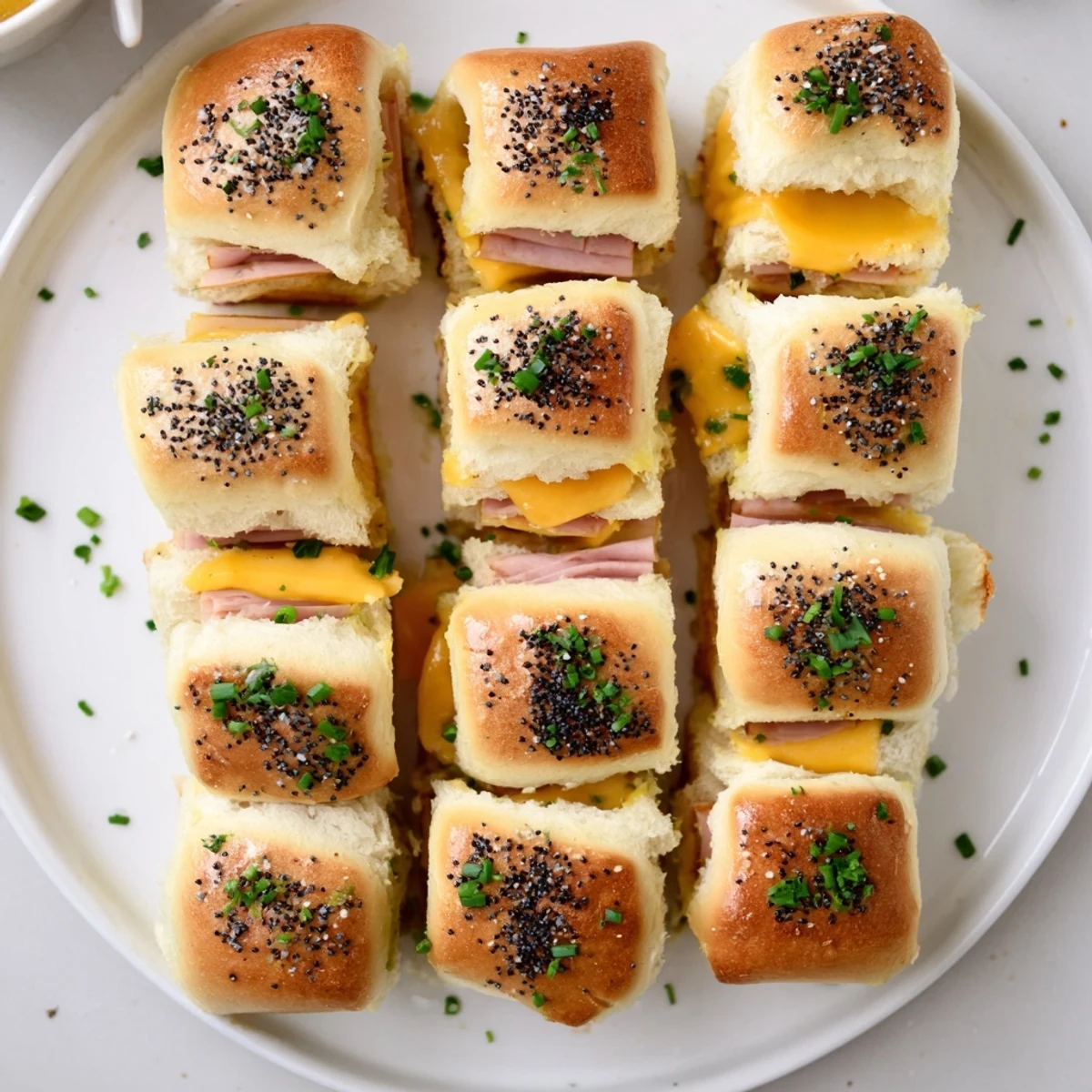 Golden sweet and savory mini grilled cheese Hawaiian rolls with melted cheddar and ham