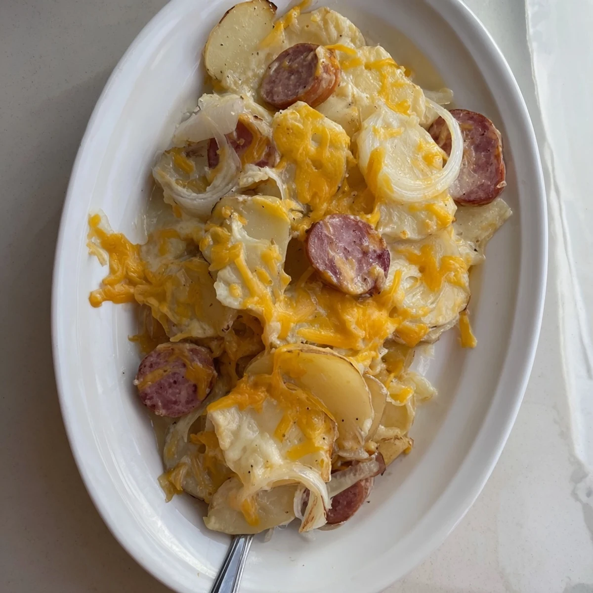 Golden bubbly slow cooker scalloped potatoes kielbasa topped with melted cheddar cheese