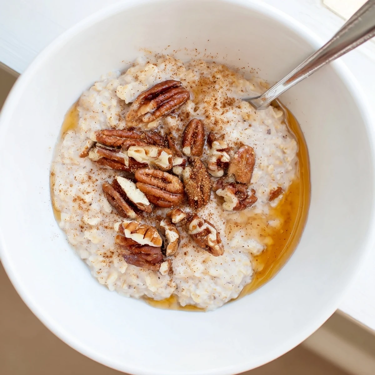 Maple cinnamon pecan overnight oats topped with crunchy nuts and a sweet maple drizzle