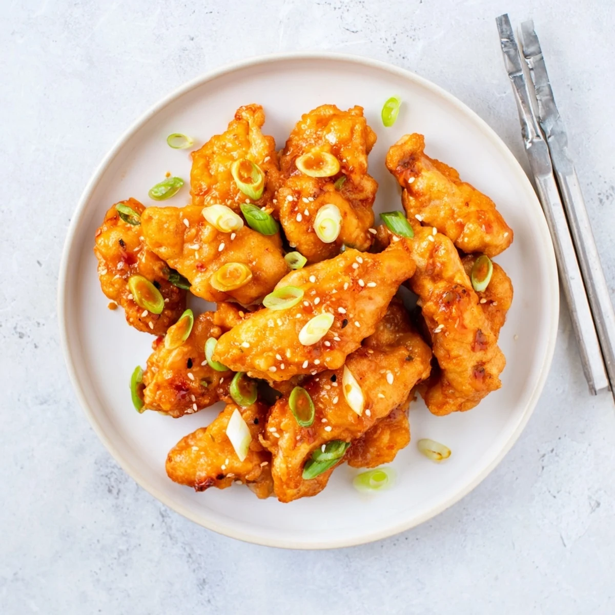 Chinese-American orange chicken featuring golden fried bites tossed in vibrant sweet and tangy glaze