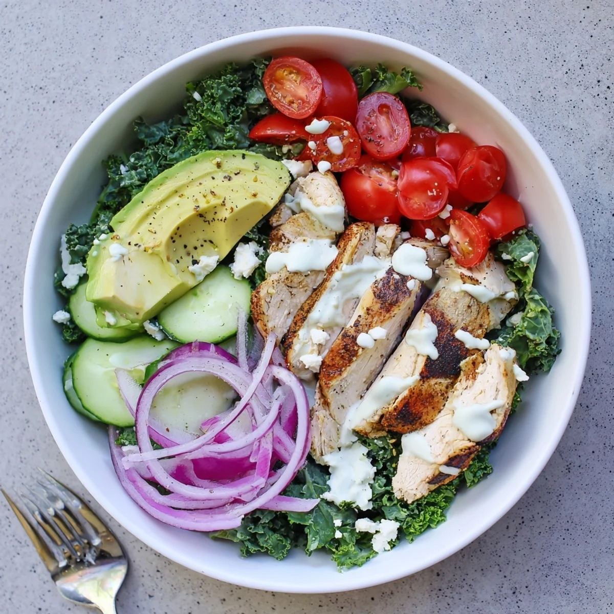 Wholesome marinated kale and chicken bowls topped with crisp veggies and tangy feta cheese