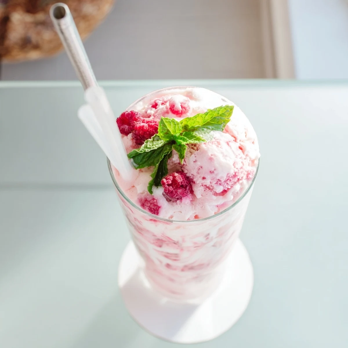 Close-up of layered Raspberry Mint Mojito Rebel Float with fizzy soda, red berries, and white ice cream swirl