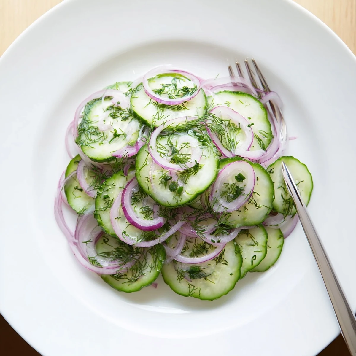 Fresh cucumber salad featuring crisp sliced cucumbers and red onions in a tangy vinaigrette