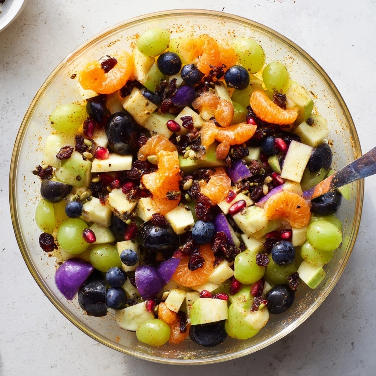 Colorful Halloween fruit salad with honey orange dressing featuring green grapes and purple plums