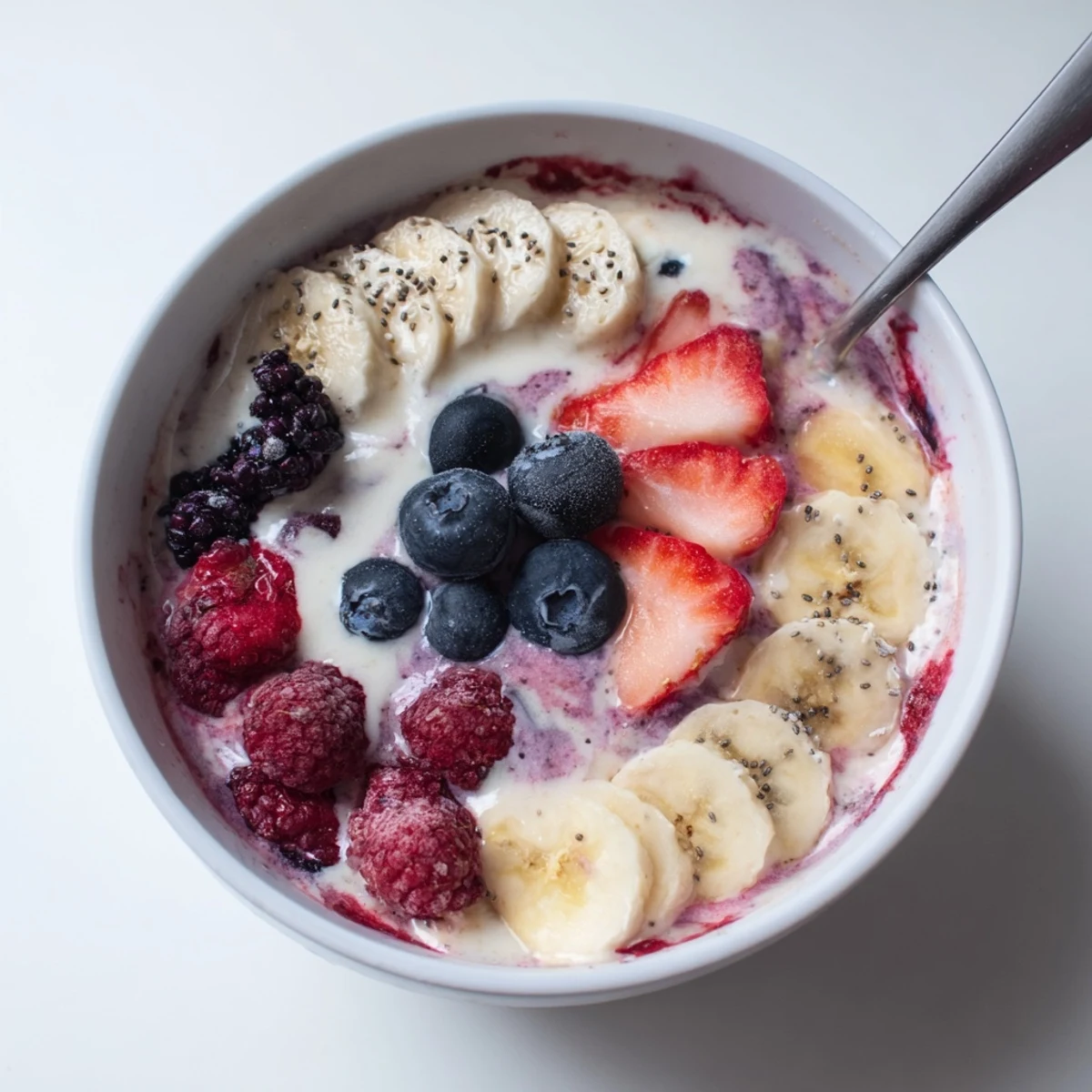 Summer Berry Smoothie in tall glass, creamy pink swirl, fresh berries garnish