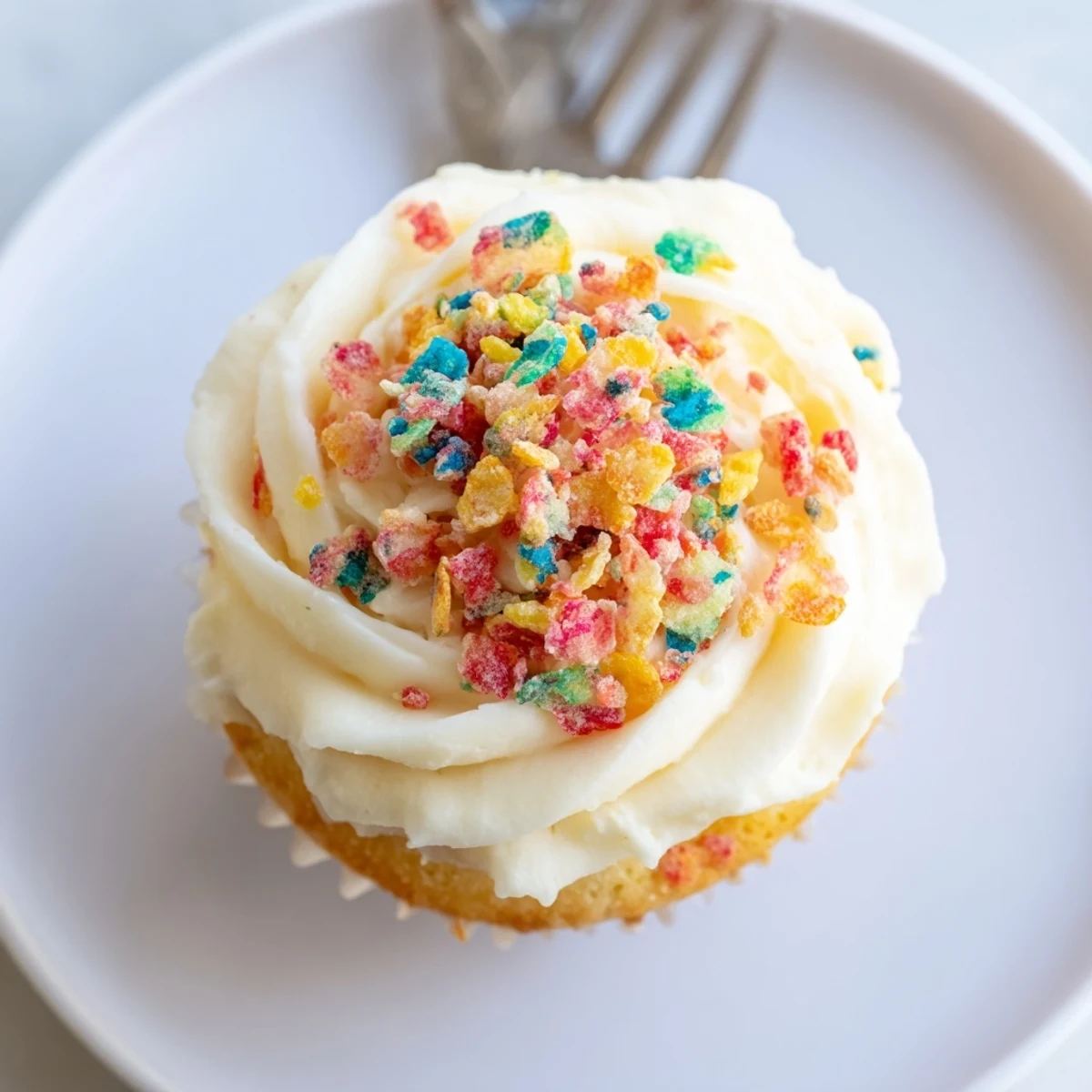 Rainbow-speckled Fruity Pebbles Cereal Frosting spread thickly, garnished with whole cereal