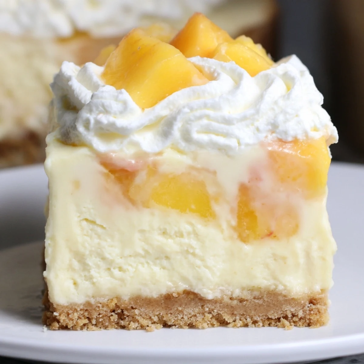 Creamy Peaches and Cream Cheesecake Bars with golden peach slices on a buttery graham crust