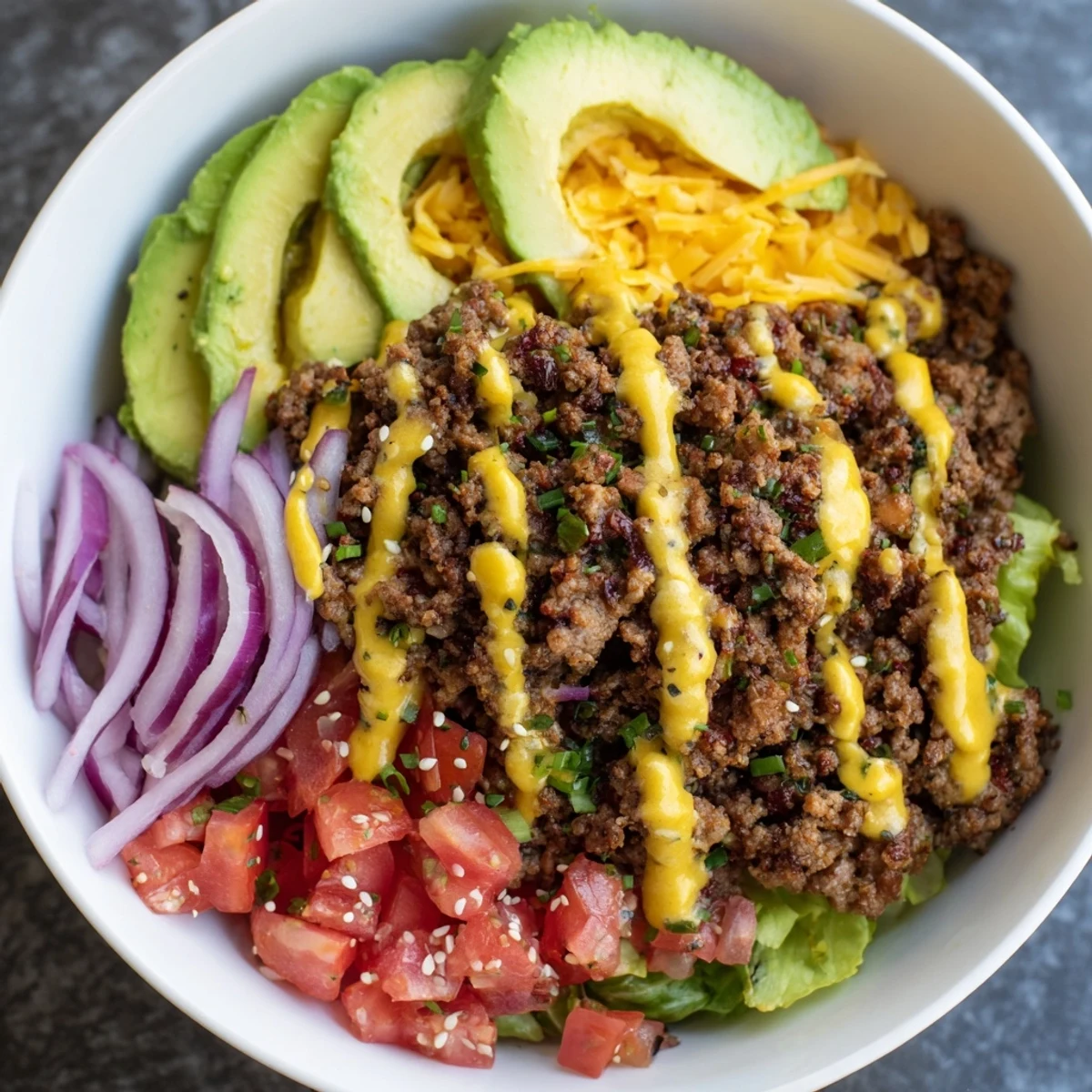 Warm seasoned beef and melted cheddar top a crisp, fresh burger bowl.