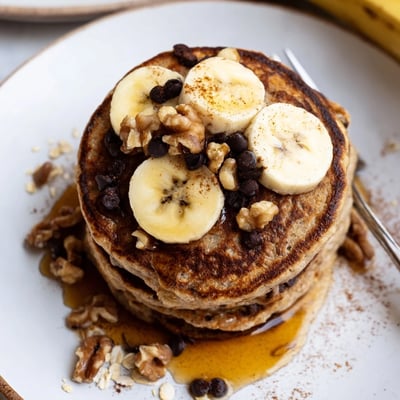 Fluffy Protein Banana Pancakes served warm with maple drizzle and berries.