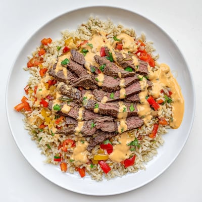 Sizzling steak queso rice topped with jalapeños and fresh cilantro garnish